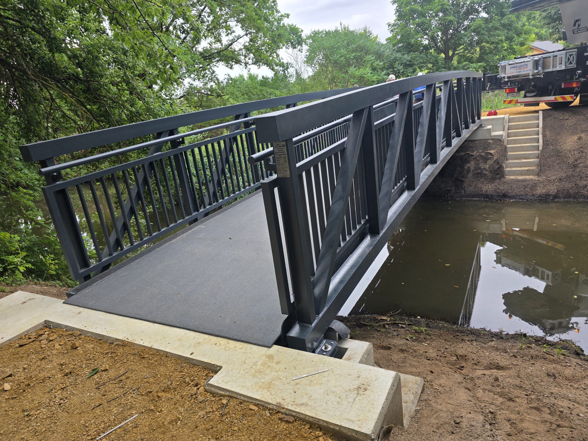 Anthracite aluminium truss footbridge over the watercourse in the Stadtpark, Doberlug-Kirchhain