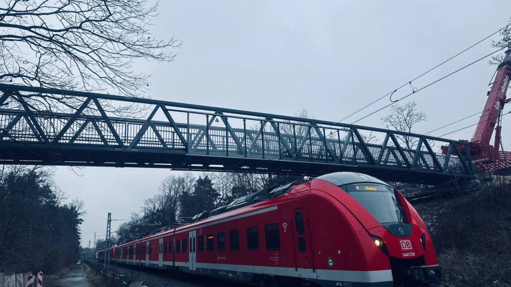 Aluminium footbridge over the railway at Fürth with a regional train passing beneath
