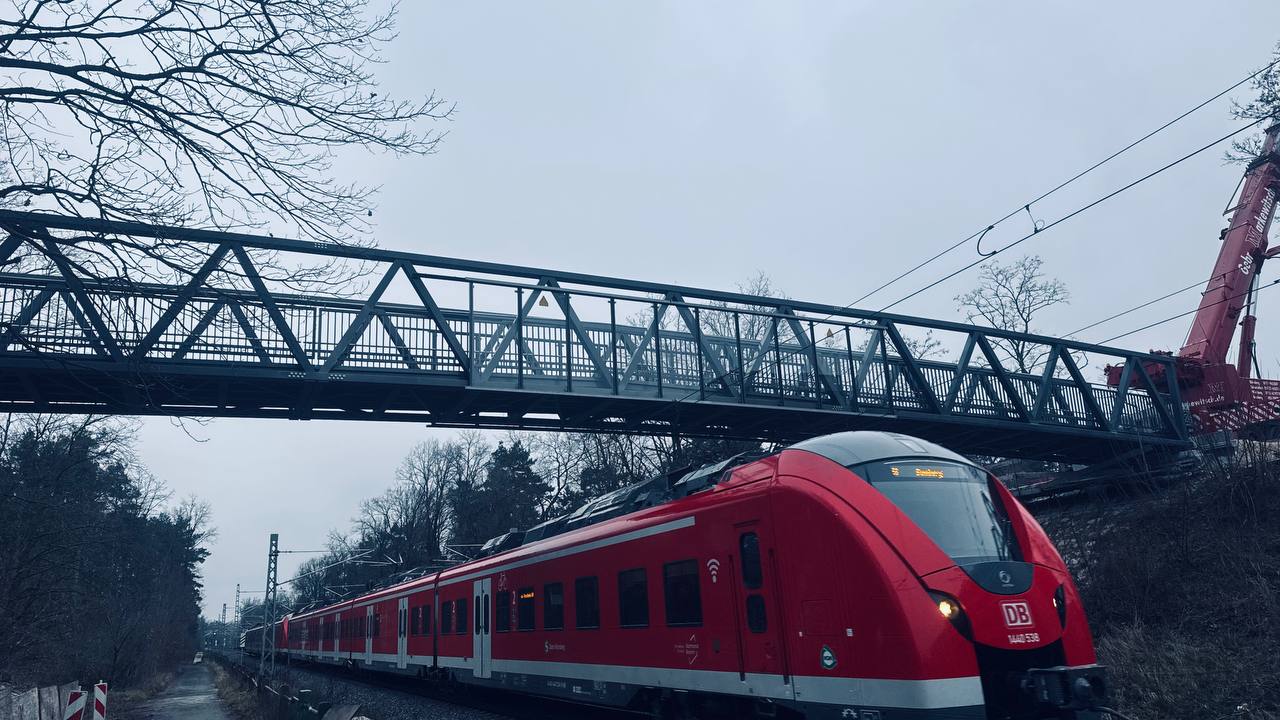 Aluminium footbridge over the railway at Fürth with a regional train passing beneath